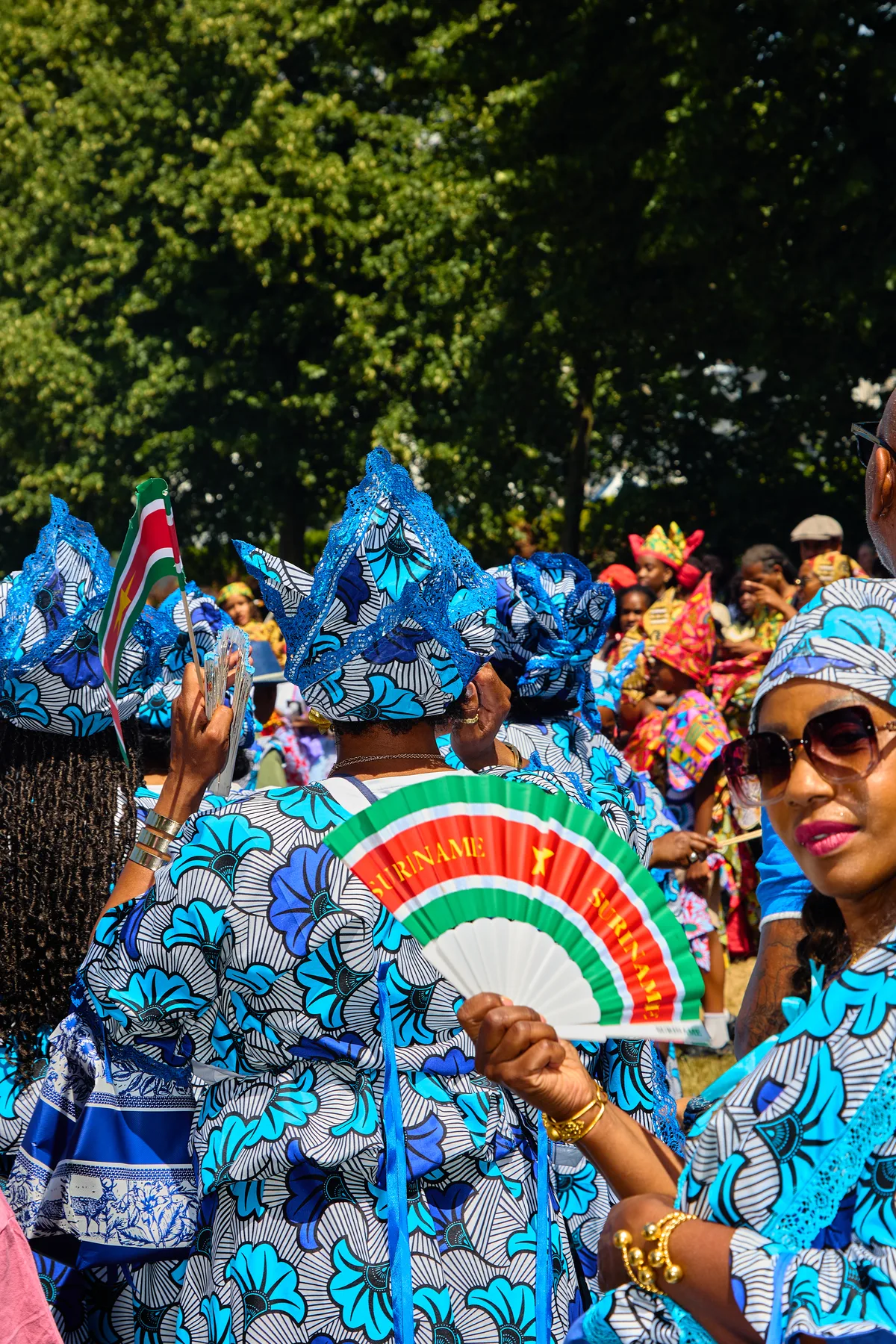Deelnemers in kleurrijke culturele klederdracht tijdens Bigi Spikri in Rotterdam
